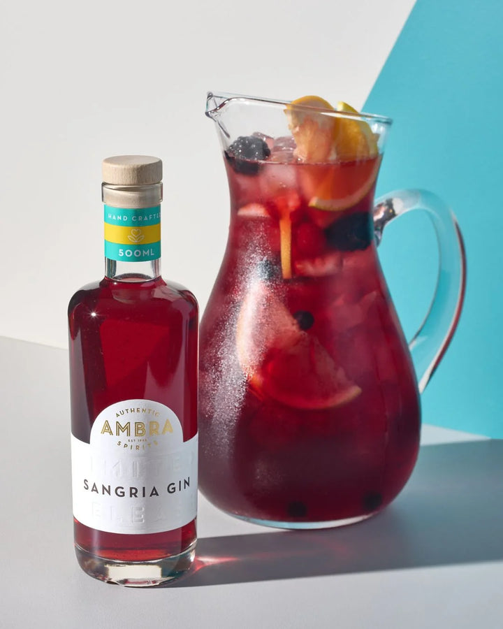 Ambra Sangria Gin 500ml bottle beside a pitcher of sangria