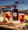Plymouth Sloe Gin bottle beside cocktails